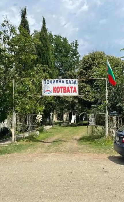 Входът на почивна база Котвата с табела и българско знаме